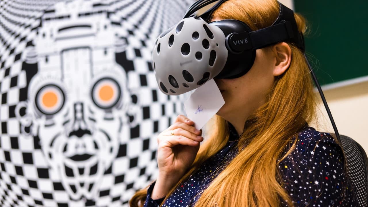 A women wearing a VR headset smells a scent sample